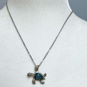 Jeweled sea turtle charm necklace on a silver tone chain